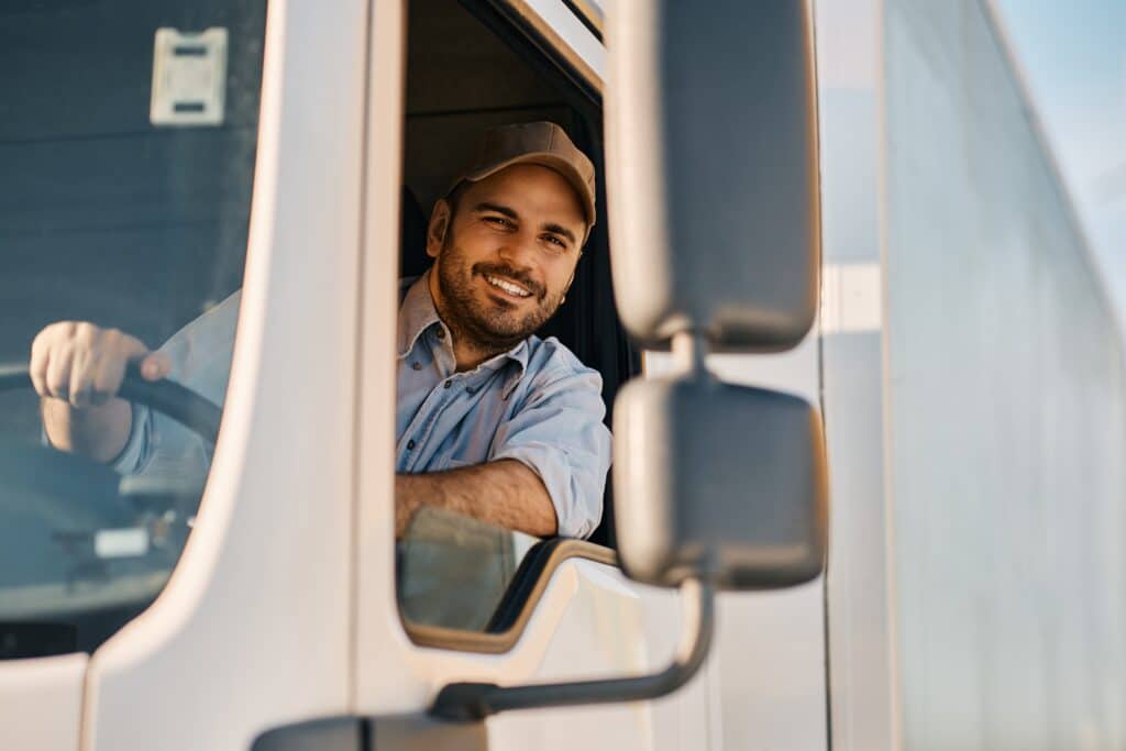 Happy,professional,truck,driver,driving,his,truck,and,looking,at Deskless Workers